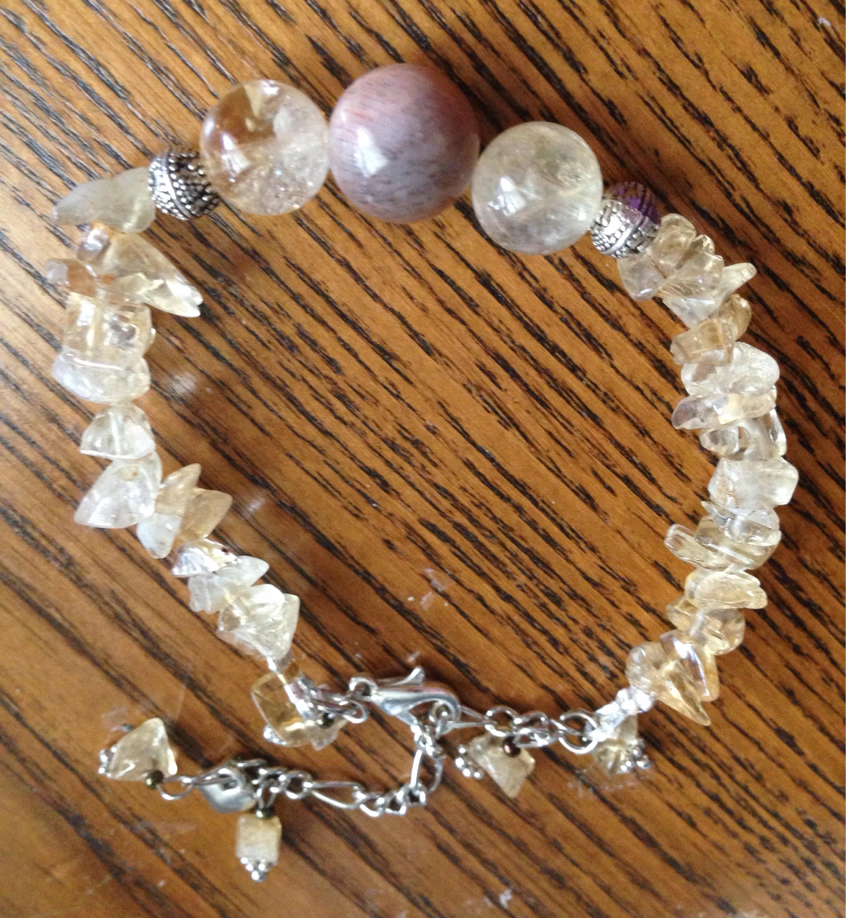 Citrine and peach moonstone chip stone bracelet with heart charm on wooden background