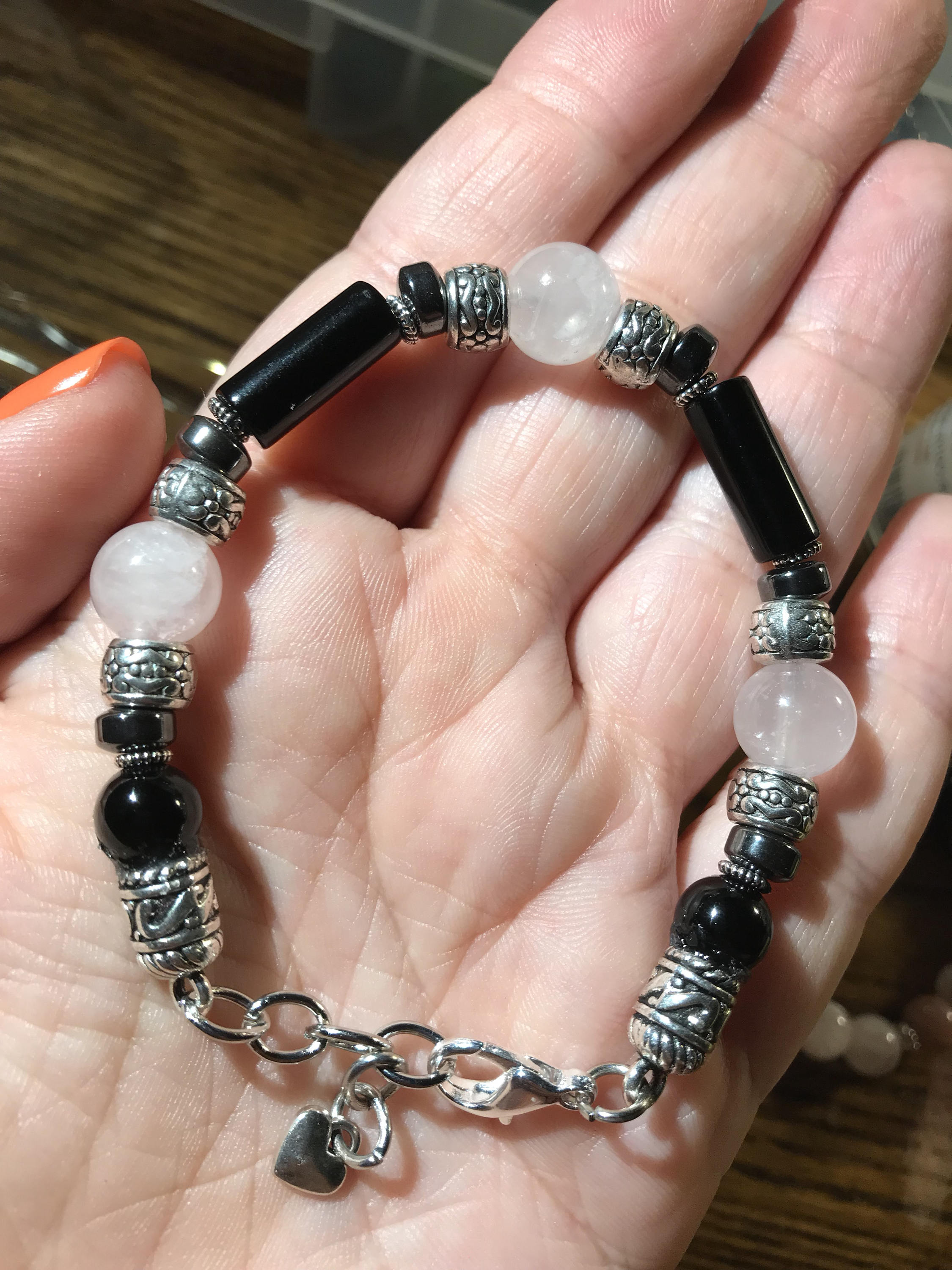 Ladies bracelet with rose quartz, hematite, black onyx, and silver accents, adjustable size for self-love and grounding.