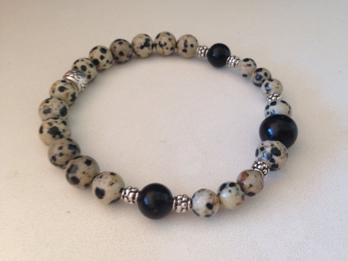 Men's bracelet made of Dalmatian jasper and jet stone beads with silver accents on a white background