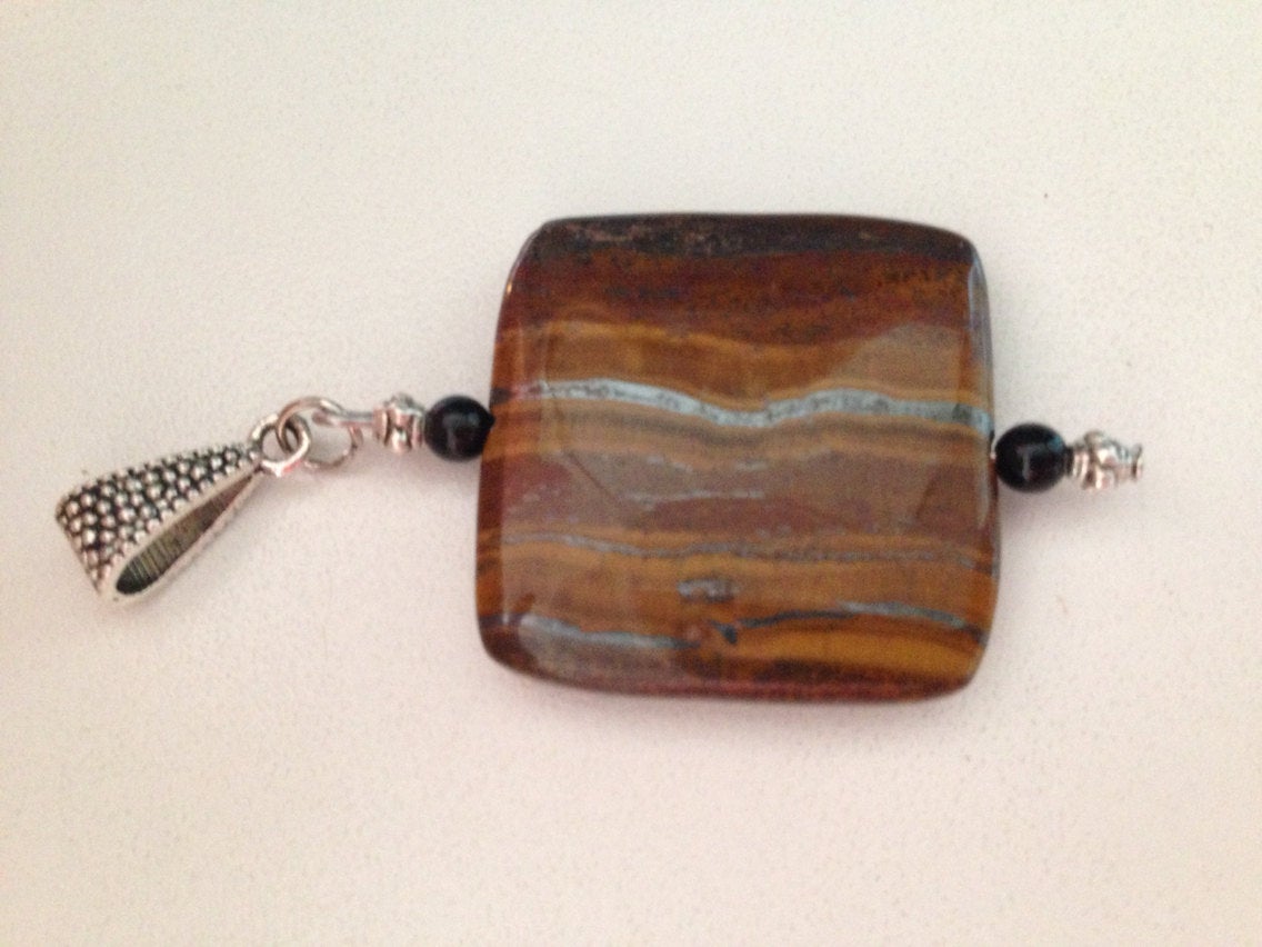 Tiger iron pendant with black onyx stone and silver bail, rectangular shape, polished surface