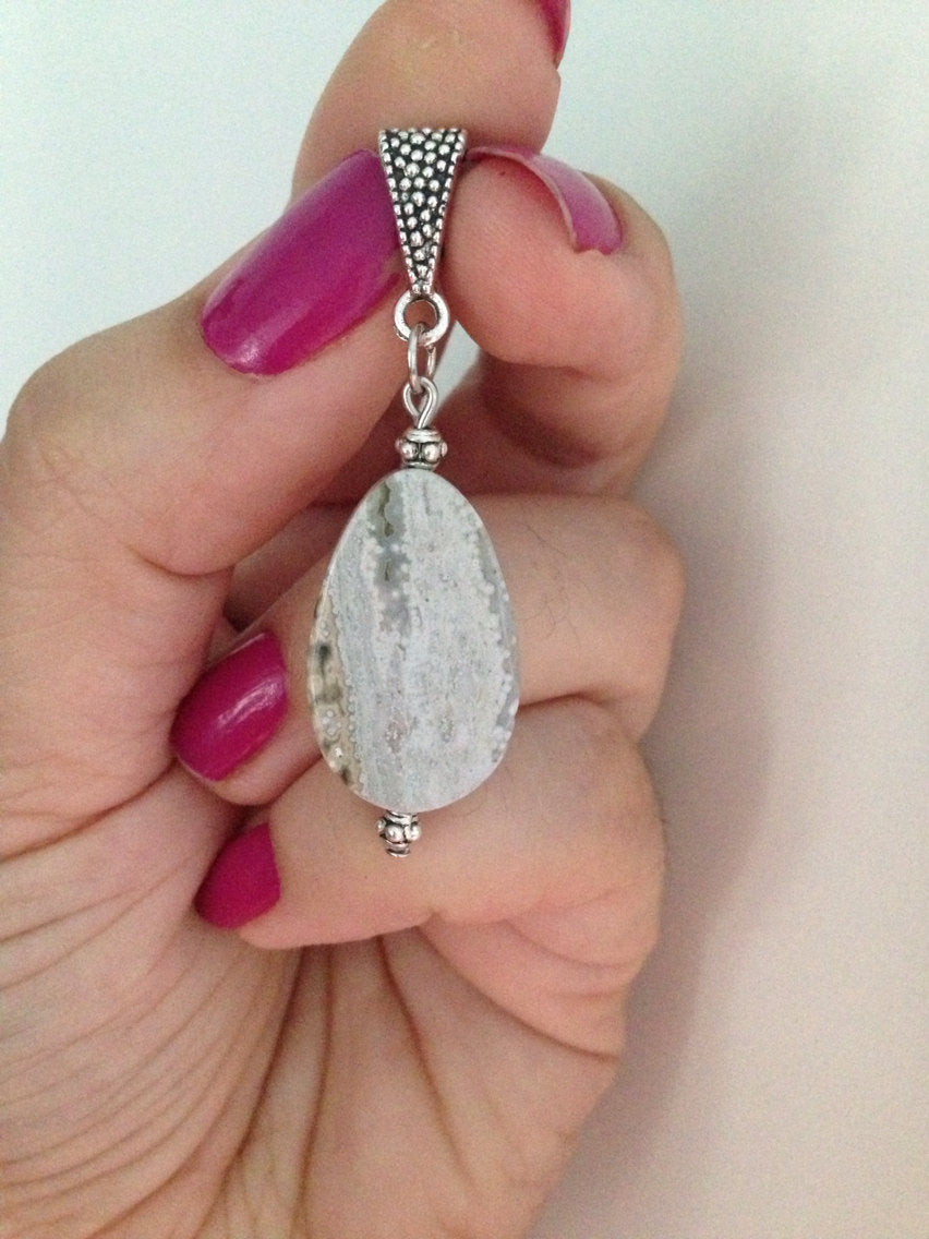 Ocean Jasper pendant teardrop stone jewelry for Cancer Zodiac held in hand