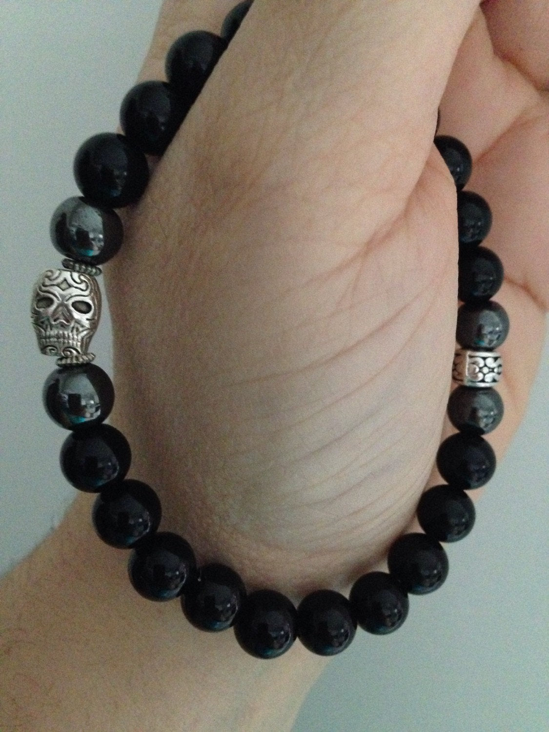SKULL mens bracelet with silver skull, black onyx, and hematite beads on wrist