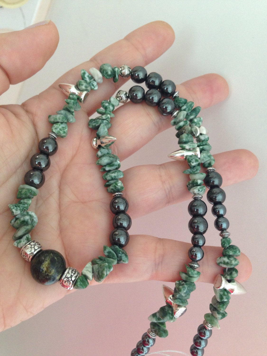 Men's necklace with tree agate, Russian serpentine, hematite beads, and spikes held in hand